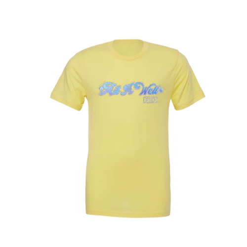 A yellow t-shirt with 'All is Well' text and a rainbow design on the front, displayed on a silver background.
